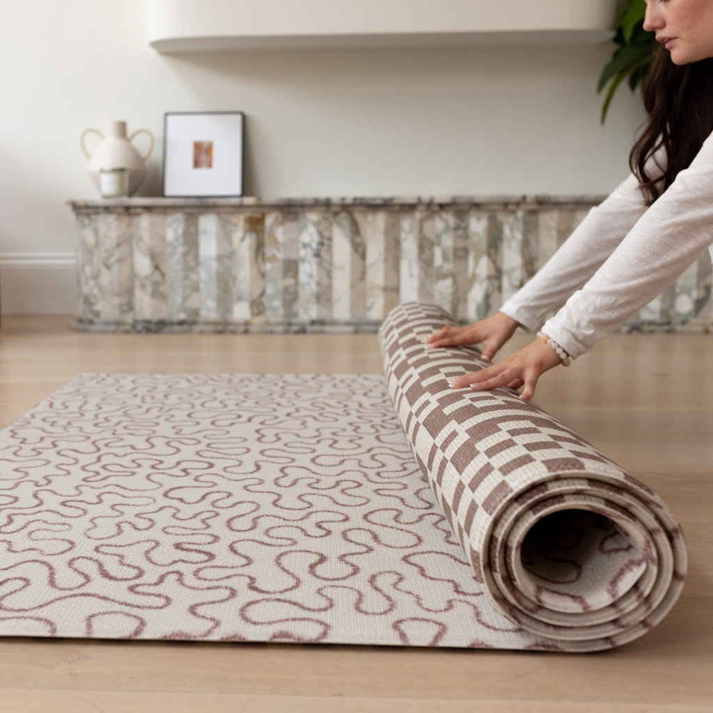 Unrolling a slate and sand playmat for a crawling baby
