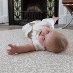 totter + tumble padded play mat in grey acorn design from william morris archive baby playing on floor mat comfy playmat for tummy time and rolling practise