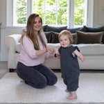 A mum and toddler play together in the living room on a soft luxury padded play mat.