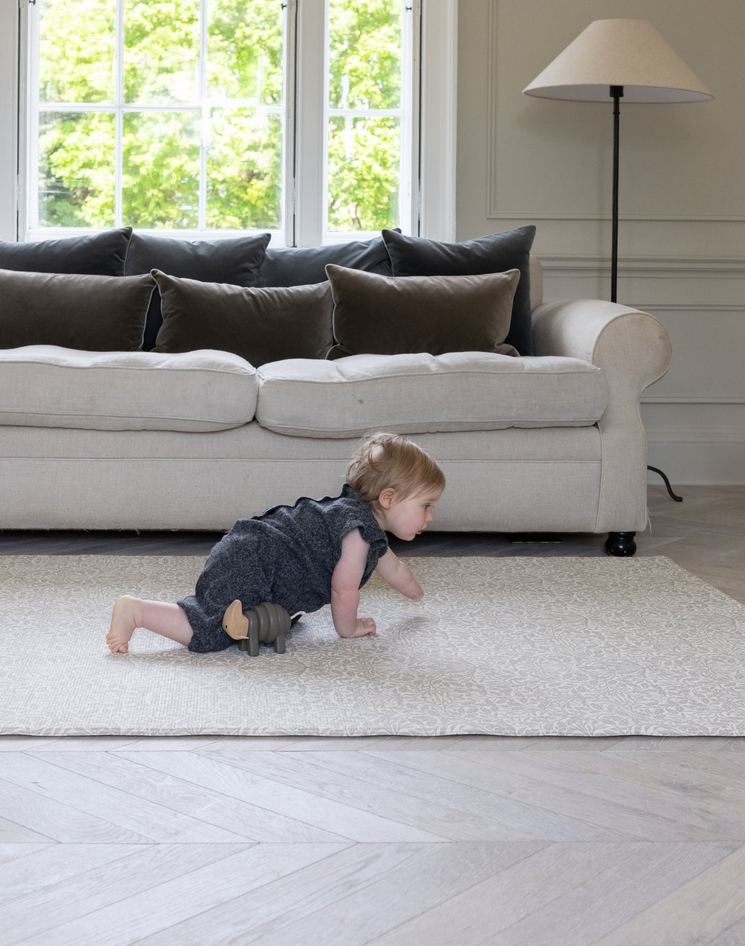 A baby crawls along a Totter + Tumble luxury playmat. It is soft and comfy for crawlers, and first steps.