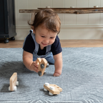 Baby boy crawls across the monochrome play mat Astronomer with a kilim design inspired by rugs