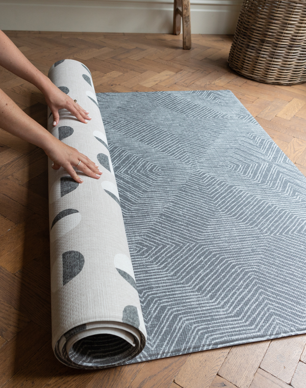 Unrolling a one piece play mat by Totter and Tumble with a reversible design so you can enjoy the organic polka dots of the Eclipse or the aged Kilim motif of the Astronomer