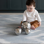 Baby playing with sensory balls on Light blue and beige play mat with subtle diamond design inspired by ikat motifs ideal for family living spaces