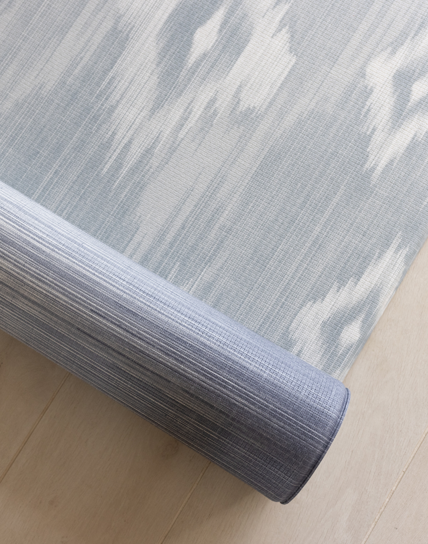 Close up of Large playmat for family home with Ikat design in soft blue and beige shades with memory foam to protect tumbles