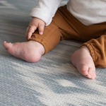 Close up of babies feet on Blue and beige baby play mat with stylish Ikat design ideal tumbling mat for babies and toddler for safe floor play thick memory foam adds comfort