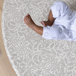 totter and tumble comfy playmat for kids and babies lying on playing in grey acorn print from william morris & co collaboration in round shape