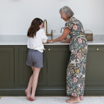 the acorn play runner in family kitchen with grandmother and child at the sink standing mat that is wipedown and easy to clean - great for the whole family to enjoy playtime together looks like a rug but actually thick padded play mat