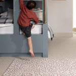 The Brecon playing mat for kids in a toddler's bedroom as he climbs on his bed. The play mat is a soft squidgy place to play
