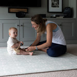 Parent engages with their baby on The Brer Rabbit Playmat, a durable and stylish play mat that complements modern classic interiors.