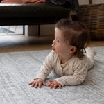 A baby is doing tummy time on a large infant play mat