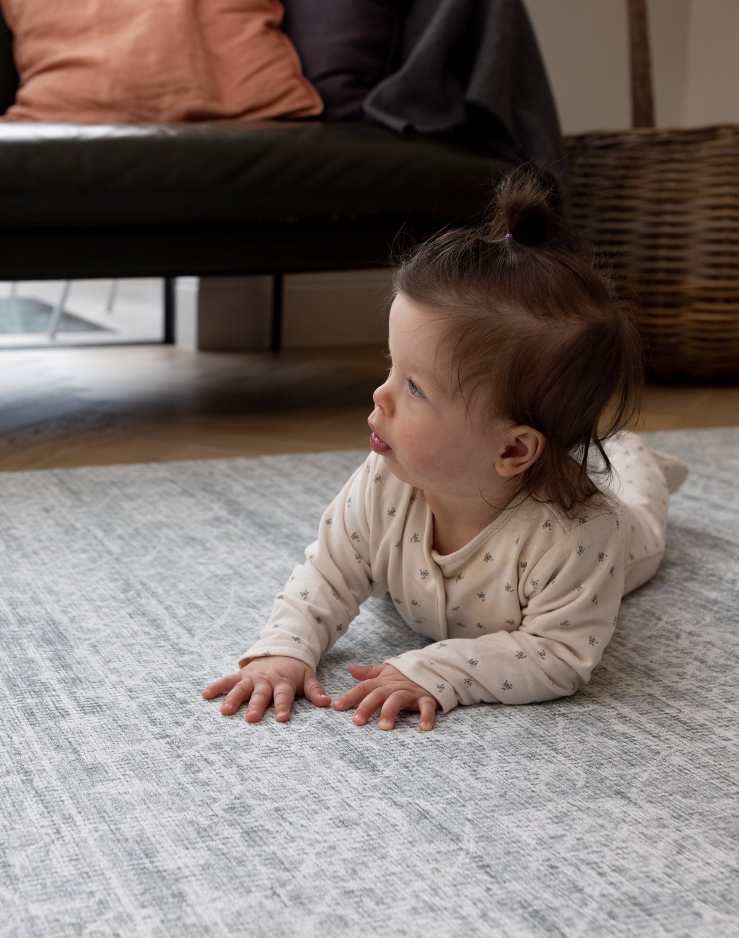 A baby is doing tummy time on a large infant play mat
