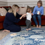 A family play together on a Morris & Co. padded play mat - modern classic interiors meet sustainable family home design.