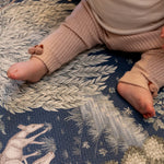 Close-up of baby’s legs during tummy time on a Totter + Tumble woodland play mat; a safe, decorative foam play mat for lovers of premium baby products.