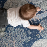 Bird’s-eye view of a baby exploring a William Morris decorative play mat - functional nursery decor meets elegant baby room ideas