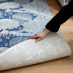 A large baby playmat is unrolled in a hallway, showing a double-sided floral design. A compact luxury playmat with rustic charm.