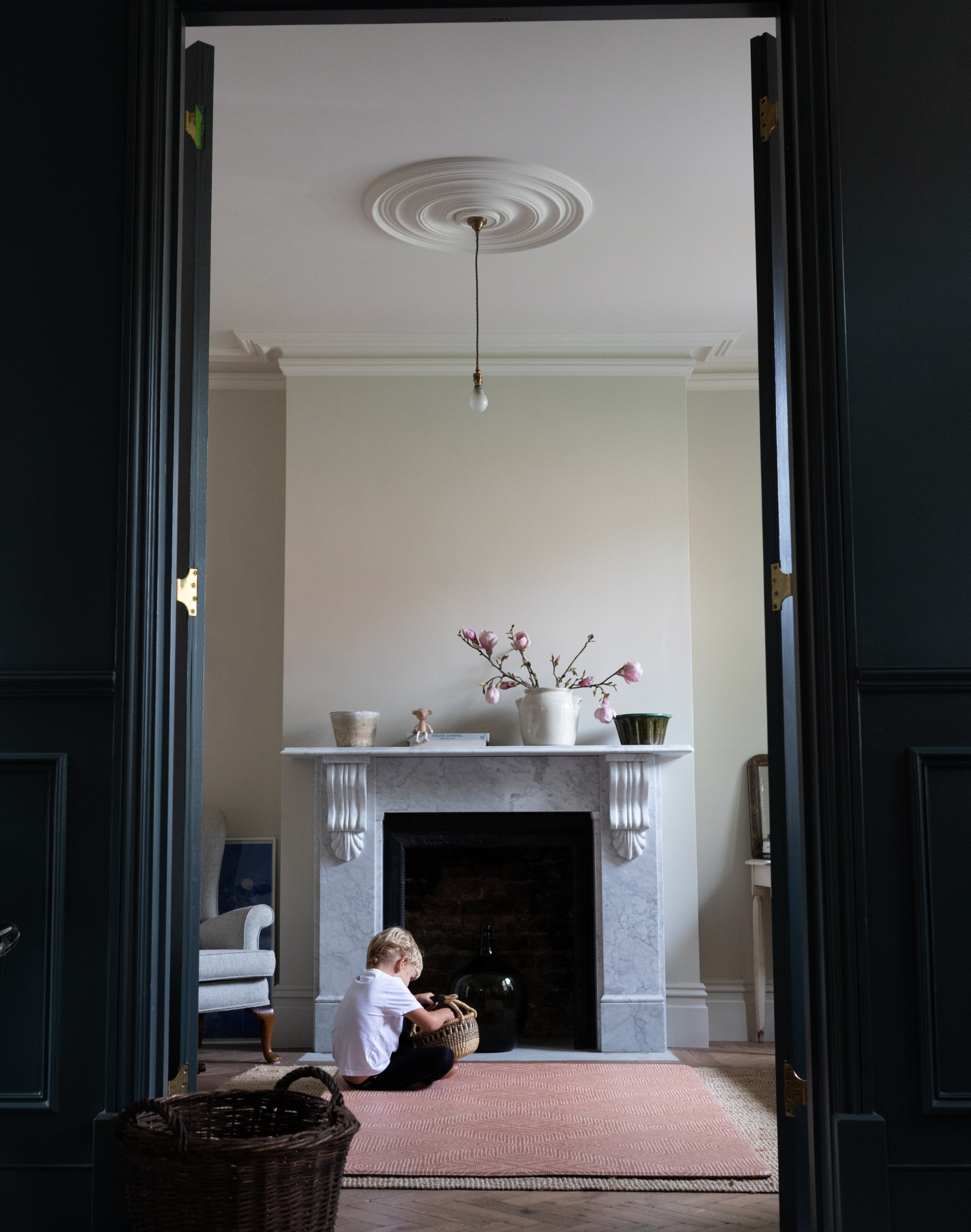 Boy plays with basket in living room sitting comfortably on durable playmat that complements modern styling
