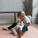 Brothers play on the terracotta tumble rug  by totter and tumble with a thick design to protect tumbles