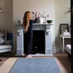 Lady arranges flowers in modern living room with large playmat that works like a rug in the room