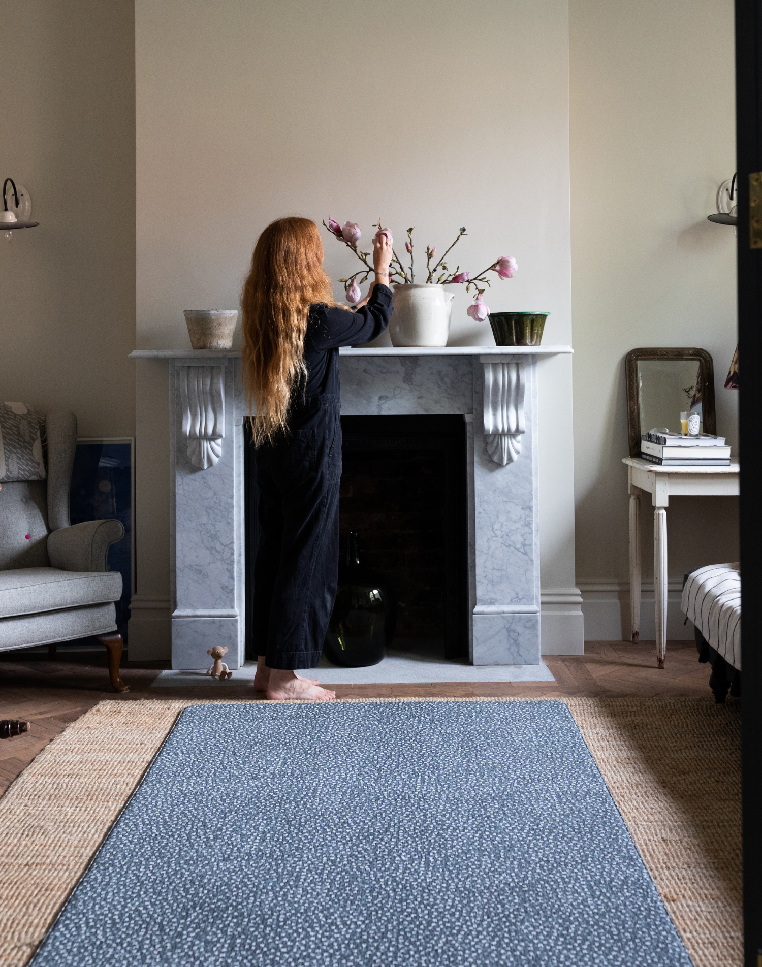 Lady arranges flowers in modern living room with large playmat that works like a rug in the room