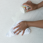 Wiping up milk spill on Globe Trotter stylish baby play mat closed cell for easier cleaning