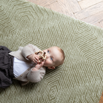 Baby plays on one piece memory foam mat with textured kilim design