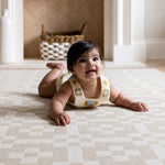 Toddler on The Holbein, a UK-designed baby mat in soft natural hues, perfect for tummy time or quiet play.
