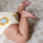 Close-up of crawling baby on The Holbein, a soft checked crawling mat with calming colours for modern nurseries.