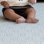 Little ones legs resting on soft baby play mat designed for support and stylish for family homes