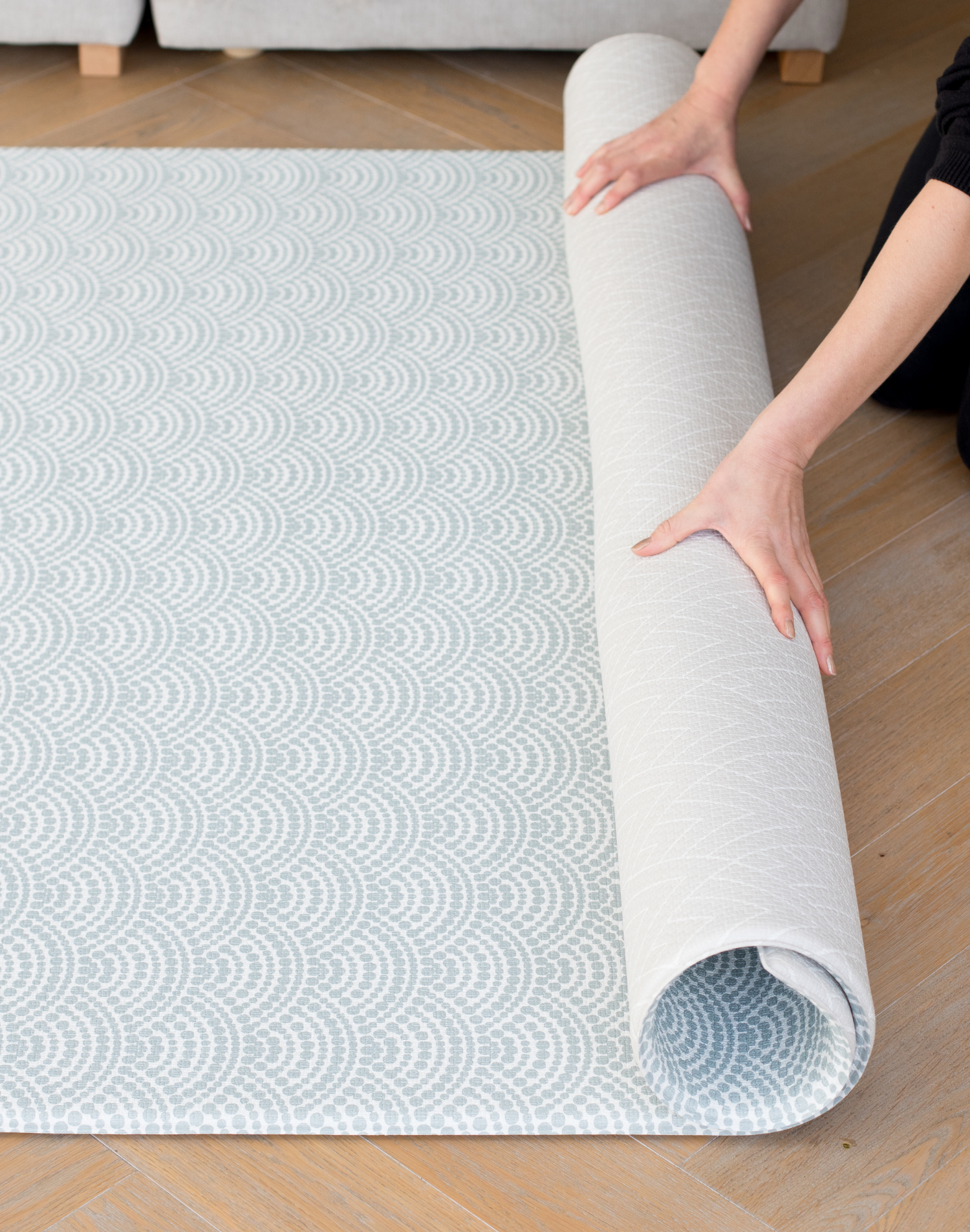 Unrolling modern one piece playmat with reversible designs created for modern family homes with a scalloped wave and vintage inspired chevron