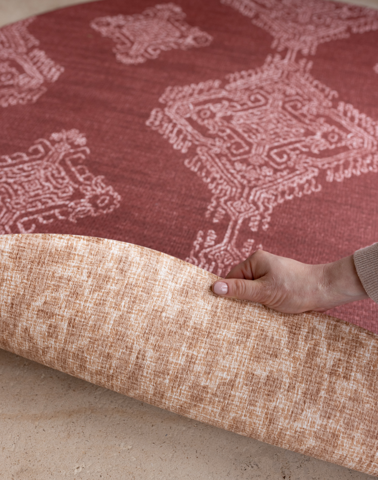 Hand folds back edge of reversible memory foam playmat with two stylish motifs created for modern family interiors
