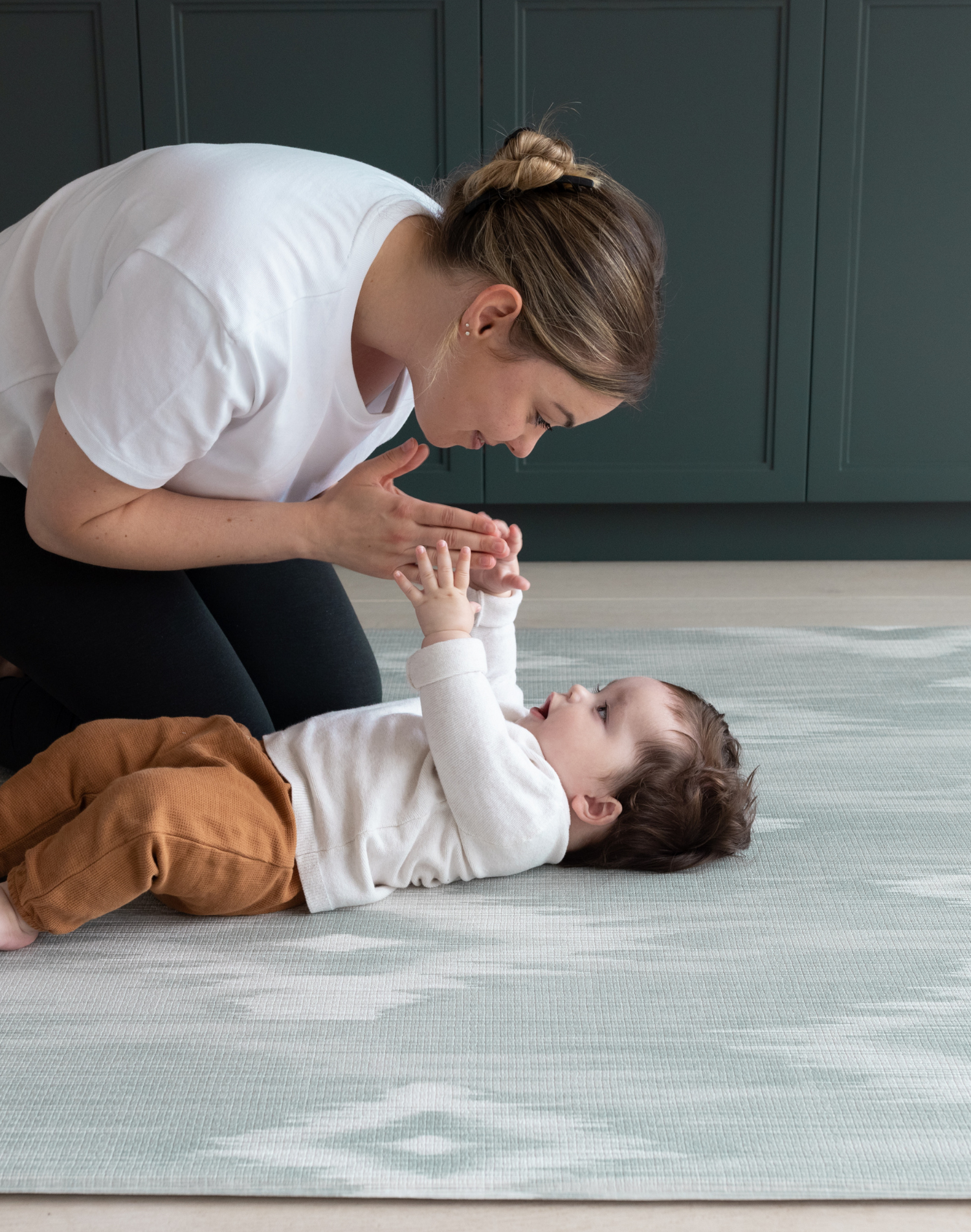 Mother and baby enjoy floor time on Thick memory foam mat for babies and adults designed for modern homes with artisan Ikat print in green and grey shades