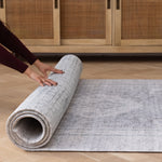 Hands roll out a rug-like baby playmat that has two elegant designs on either side