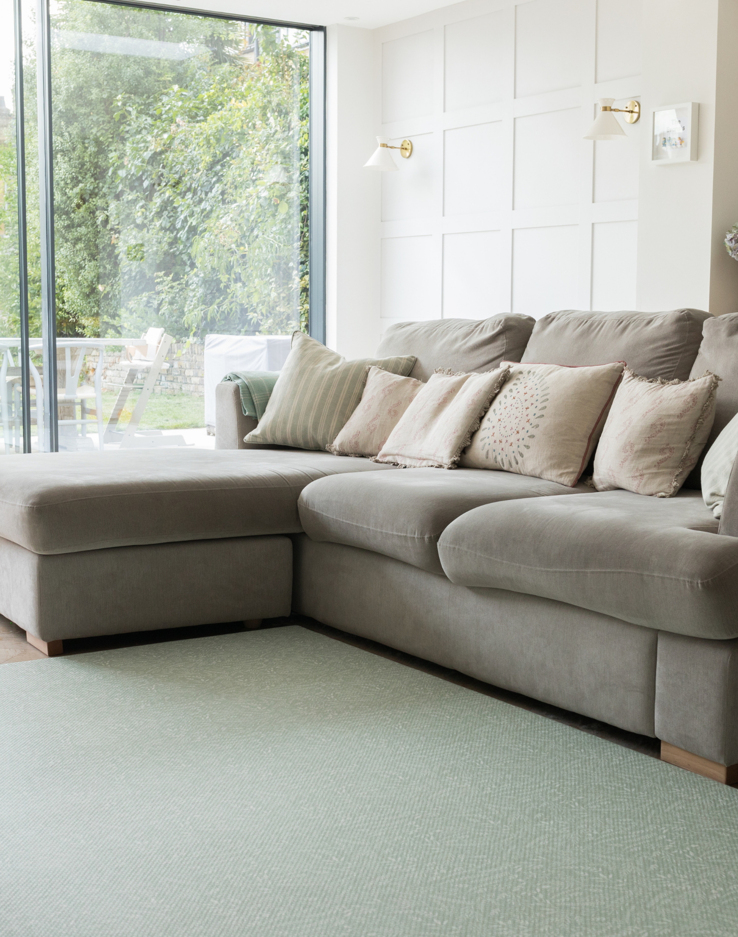 A family living space looks contemporary with near neutrals beige tones and a green playmat designed to complement warm and cool spaces