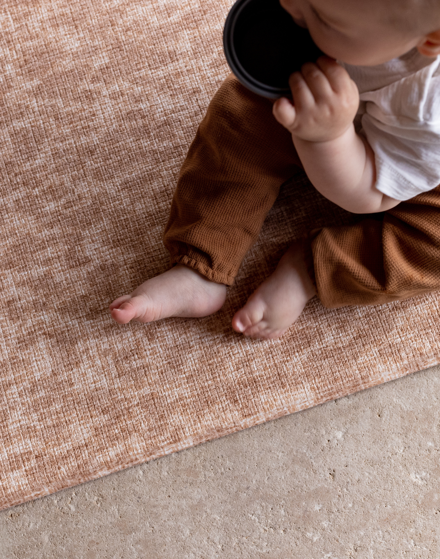Baby sits unaided on protective memory foam playmat the Rusa featuring a delicate animal print motif that complements modern homes