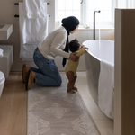 Mother and baby prepare for bath time keeping comfortable on the memory foam bath room mat the sepi with a grey design that sits subtly in modern bathroom designs also use the mat as a kitchen mat runner or exercise mat in the home