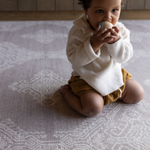Baby kneels on memory foam play mat The Sepi to support play time and floor time activities the delicate design complements modern boho family interiors
