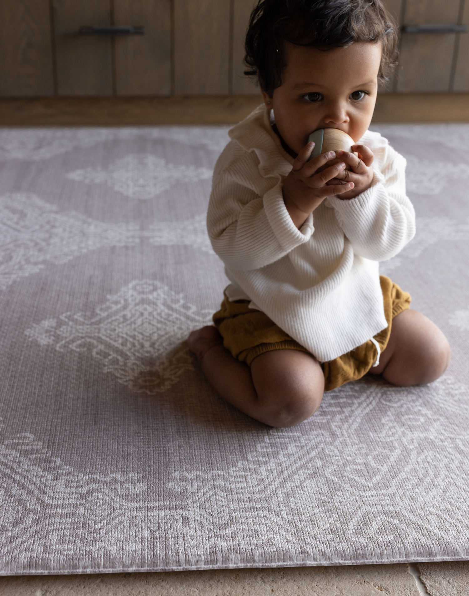 Baby kneels on memory foam play mat The Sepi to support play time and floor time activities the delicate design complements modern boho family interiors