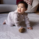 Baby crawls across supportive play mat with thick memory foam for ultimate protection and support the flexible grey design features a hand drawn Batik inspired pattern that has a textile aesthetic to complement modern interiors