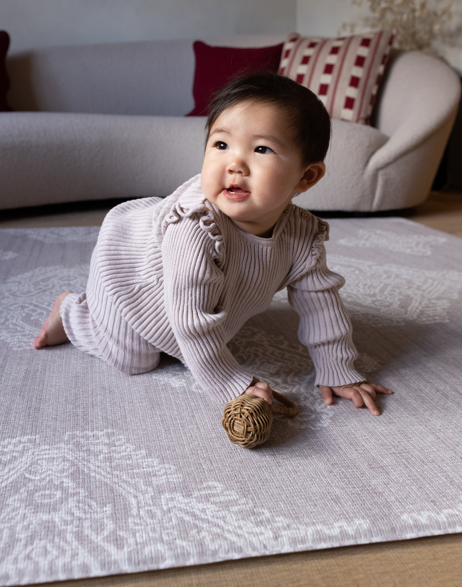 Baby crawls across supportive play mat with thick memory foam for ultimate protection and support the flexible grey design features a hand drawn Batik inspired pattern that has a textile aesthetic to complement modern interiors