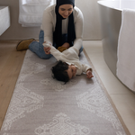 Mother changes baby girl on the large bathroom mat the sepi ideal as a kitchen mat and exercise mat in the home too with a gentle grey design to style seamlessly into modern family interiors