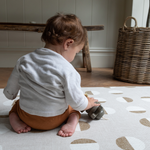Little boy kneels on knee saving playmat with luxury memory foam for support