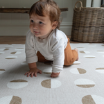 Baby crawls across neutral playmat with modern design to complement family interiors