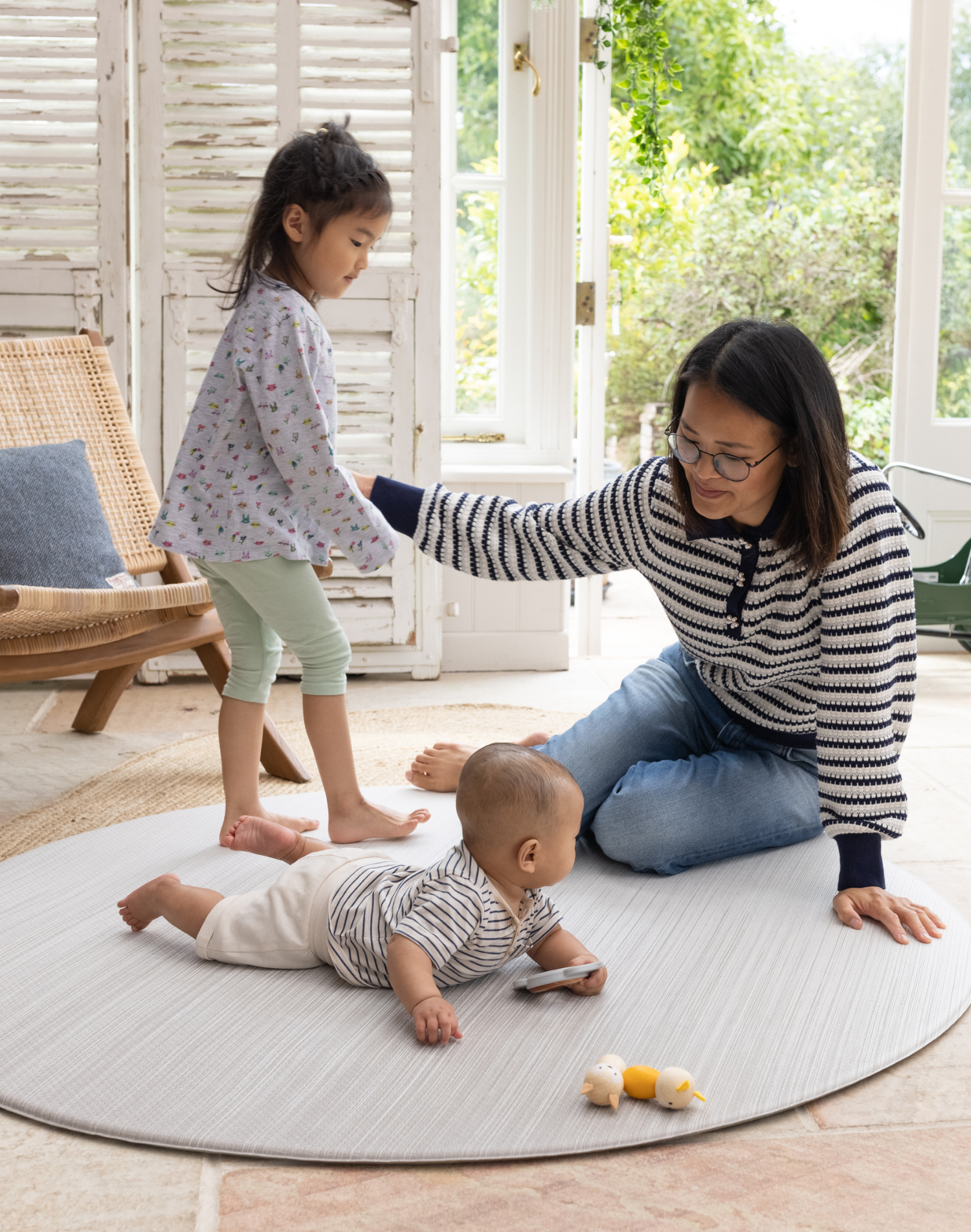 Mother enjoys floor play with baby and toddler on Beige baby play mat made with memory foam and a beautiful gradient motif