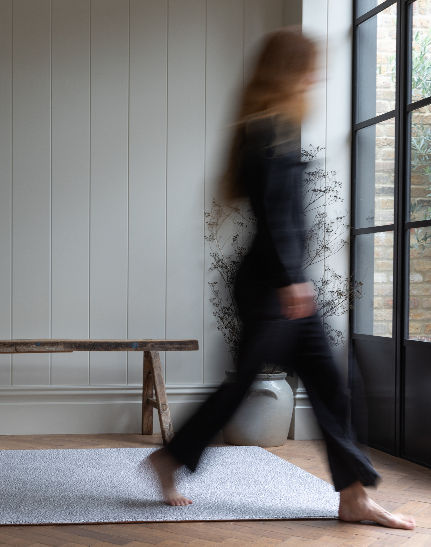 Figure walks across the stylish, anti-slip foam playmat by totter and tumble with a modern grey design