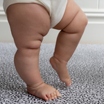 Little legs are supported on the memory foam surface of totter and tumble leopard baby playmat