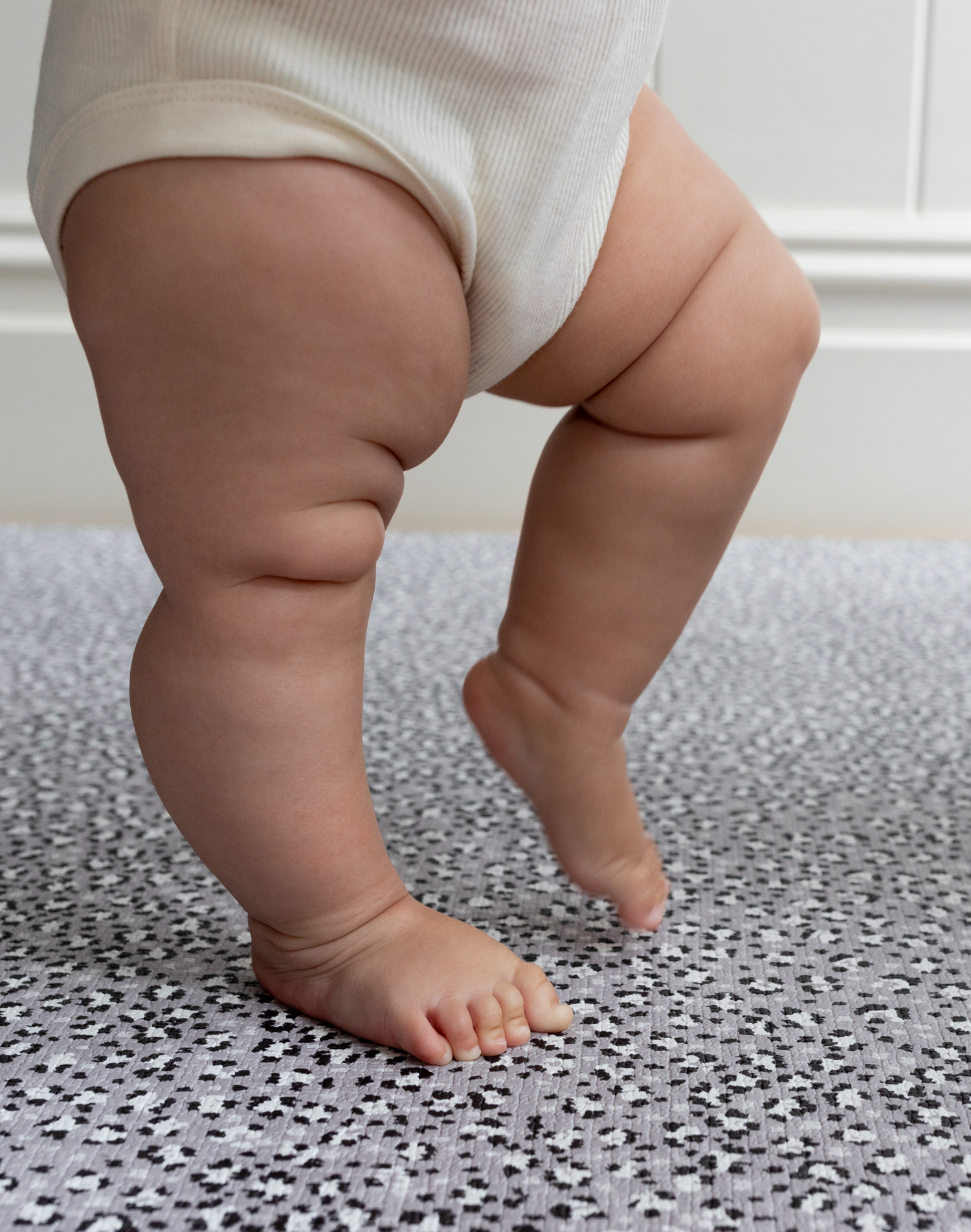 Little legs are supported on the memory foam surface of totter and tumble leopard baby playmat