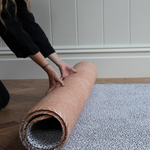 Rolling out reversible playmat with orange and grey designs perfect for modern homes