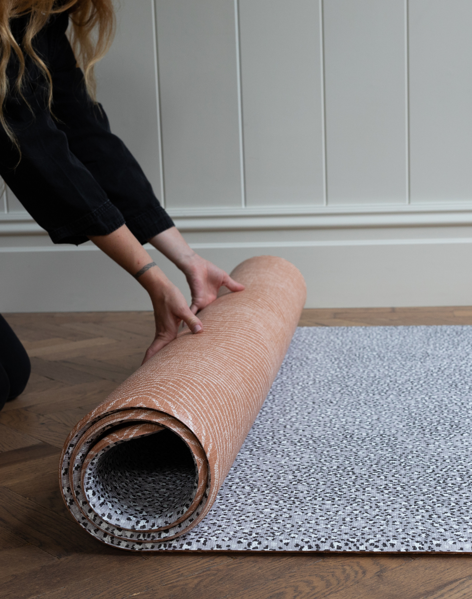 Rolling out reversible playmat with orange and grey designs perfect for modern homes