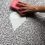 Wiping up milk spillage with sponge on wipeable playmat by totter and tumble