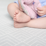 Baby feet rest on foam playmat providing support and protection for sitting